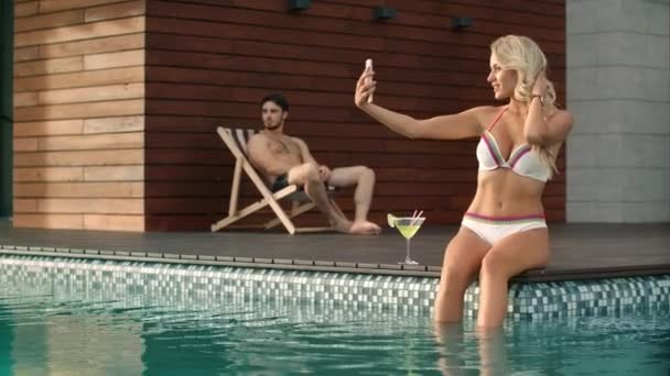 Slanke vrouw die selfie foto neemt in zwembad bij Luxury House. — Stockvideo