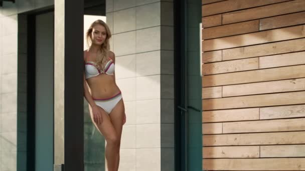 Sexy Frau steht in der Nähe von Luxus-Wohnung im Badeanzug. Porträt einer Luxusfrau — Stockvideo
