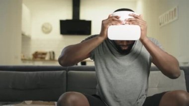 Genç siyah adam mutfakta video gözlük koyarak. Üzgün adam alma kapalı VR