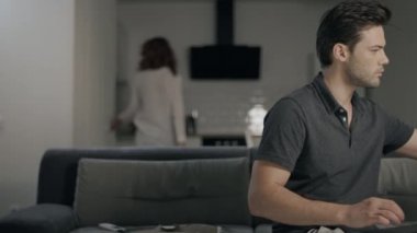 Gece mutfakta dizüstü bilgisayar üzerinde çalışan konsantre iş adam.