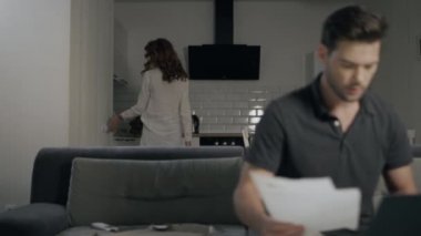 Ev mutfağında dizüstü bilgisayar üzerinde çalışan ciddi iş adam