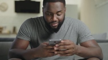 Mutfakta telefon tutan gülümseyen erkek kişi. Ciddi guygetting kötü haber.