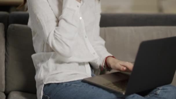 İş hanım evde kanepede telefon konuşuyor. Laptop üzerinde çalışan mutlu kadın. — Stok video