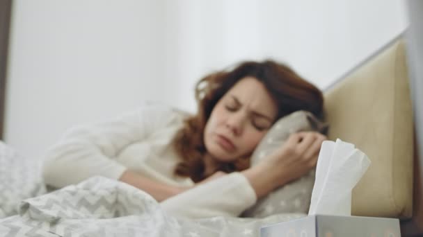 Mujer enferma sintiéndose mal en el dormitorio. Mala persona femenina estornudando en la cama . — Vídeos de Stock