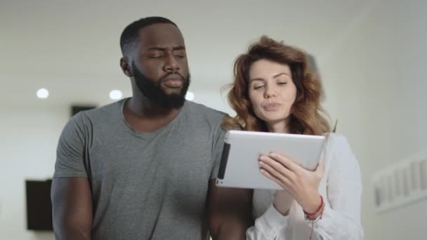 Young couple standing at living room with tablet together. — Stock Video