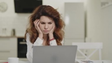 Uzak işyerinde bilgisayar çalışan ciddi bir kadın. Pensive kız bakmak Notebook