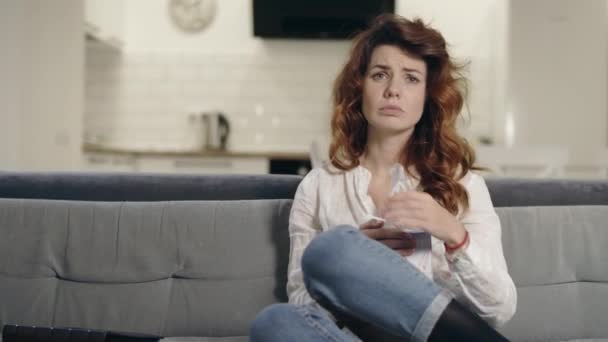 Açık mutfakta TV izlerken üzgün kadın. Closeup depresif kadın yüz silme — Stok video