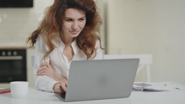 Улыбающаяся женщина читает радостные новости на ноутбуке. Счастливая барышня ищет компьютер — стоковое видео