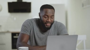 Siyah adam açık mutfağa gülüyor. Kırmızı saç kadın temizlik mutfak masası.