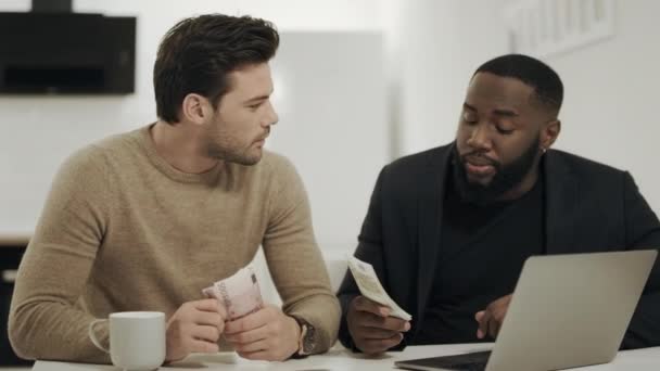 Deux hommes d'affaires assis à la cuisine ouverte avec de l'argent dans les mains . — Video