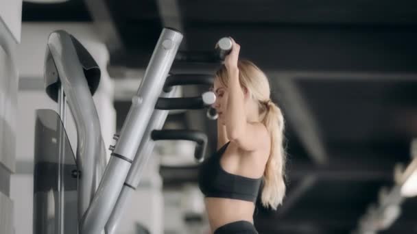 Fitness meisje doet pull ups oefeningen in moderne sportschool. — Stockvideo