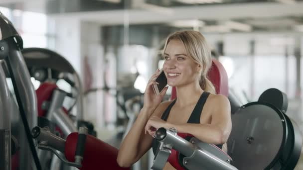 Mulher bonita usando telefone celular após o treinamento de fitness . — Vídeo de Stock