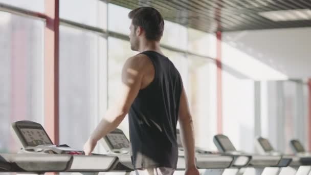 Athlète homme marchant sur tapis roulant dans le centre de fitness . — Video
