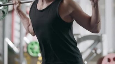 Fitness kulübünde halter ile sporcu eğitimi squat egzersiz.