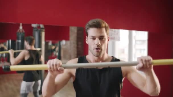 Joven saltando con barra transversal en el entrenamiento de fitness en el gimnasio club — Vídeos de Stock