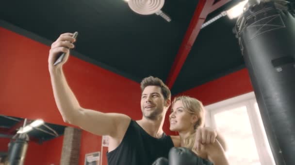 Omfamna Fitness par poserar till mobiltelefon för selfie i gym Club. — Stockvideo