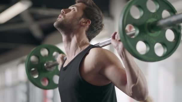 Atleta hombre en cuclillas con barra de peso en el entrenamiento culturismo en el gimnasio — Vídeo de stock