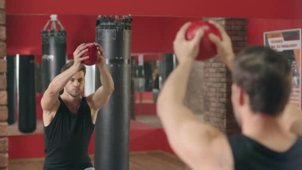 Fitness hombre entrenamiento en cuclillas ejercicio con pelota en gimnasio fitness . — Vídeo de stock