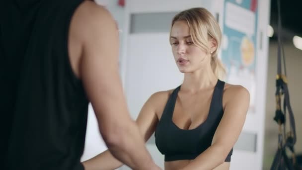 Gülümseyen fitness kadın spor kulübünde kişisel antrenör el tutarak. — Stok video