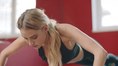 Fitness kadın spor kulübünde katta egzersiz kadar iterek. Spor salonunda pratik yapan kız