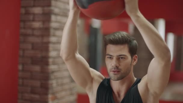 Hombre guapo haciendo ejercicio en cuclillas con pelota en el gimnasio . — Vídeos de Stock