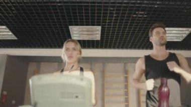 Spor çift eğitim fitness kulübünde koşu bandı makine üzerinde çalıştırmak.