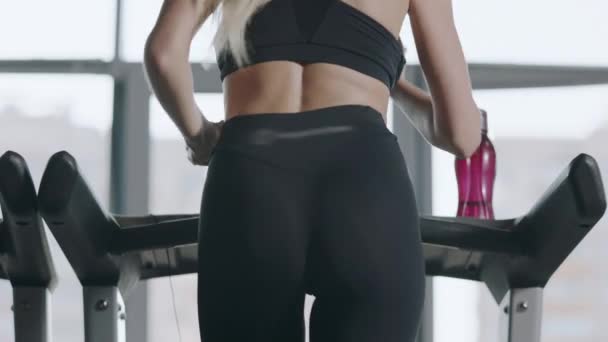 Rückseite Sport Frau trainiert Beinbeugung am Laufband im Fitnessstudio. — Stockvideo