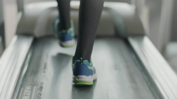 Gros plan jambes en cours d'exécution sur tapis roulant dans le gymnase de remise en forme. Vue arrière des chaussures de fitness — Video