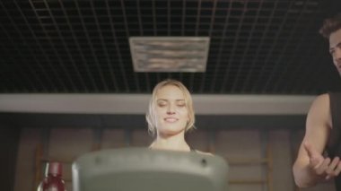 Gülümseyen fitness çift spor kulübünde koşu bandı makine üzerinde konuşurken