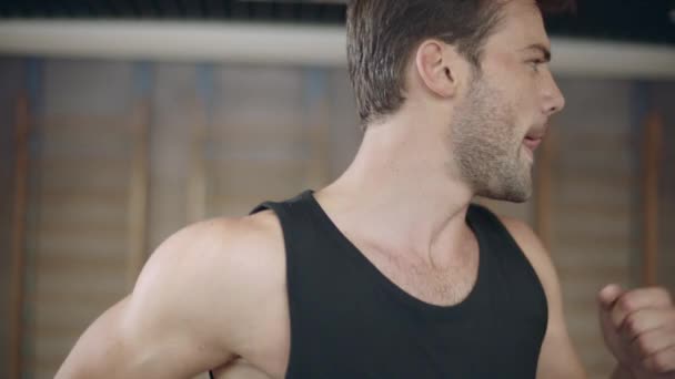 Portrait of handsome man running on treadmill machine in fitness club. Closeup — Stock Video