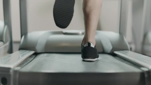 Close-up atletische voeten lopen op loopband in fitness gym. — Stockvideo