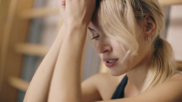 Portrait of upset girl sitting in fitness gym. — Stock Video