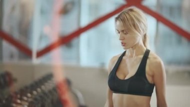 Sarışın kız sırayla dambıl ile egzersizleri pratik.