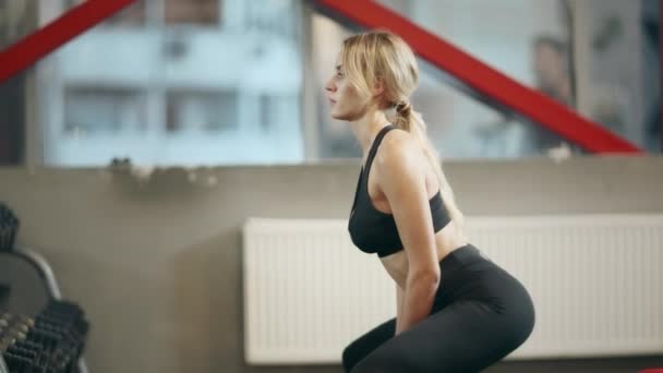 Sportswoman kraken met dumbbells in het fitnesscentrum. — Stockvideo