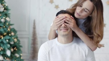 Gülümseyen aile lüks evde yeni yılı kutluyor. Hediye sunan güzel karısı