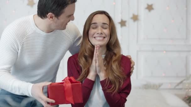 Mujer bonita esperando regalo con los ojos cerrados en la sala de estar . — Vídeo de stock