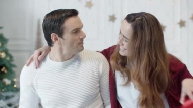 Noel tatilinde bilgisayar başında çalışan ciddi bir adam. Hediye sunan gülümseyen kadın