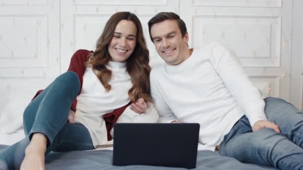 Pareja feliz viendo la película en el ordenador en casa juntos . — Vídeos de Stock