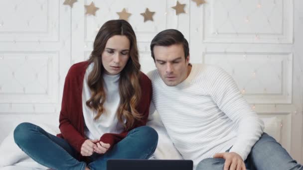 Расстроенная пара, смотрящая ужасные новости на компьютере вместе . — стоковое видео
