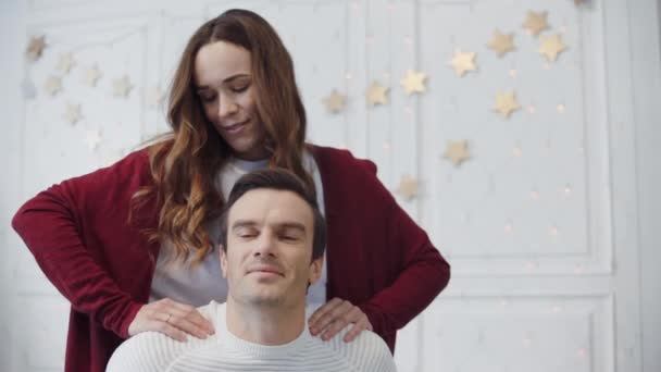 Entspanntes Paar massiert im Wohnzimmer. Lächeln Frau macht Massage — Stockvideo