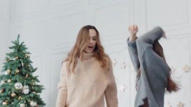 Neşeli anne ve kızı lüks evde yatakta dans. Closeup mutlu aile