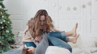 Gülümseyen aile birlikte uyku odasında yatakta birbirlerini gıdıklama.