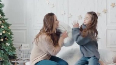 Gülümseyen bayanlar lüks dairede yatakta yastık mücadele başlangıç.