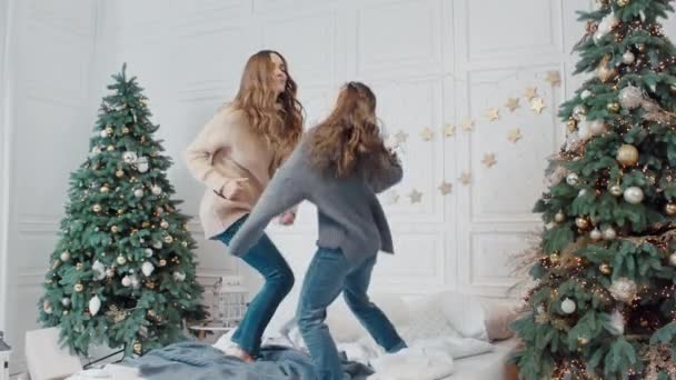 Happy mother and daughter making dance party on bed in private house. — Stock Video