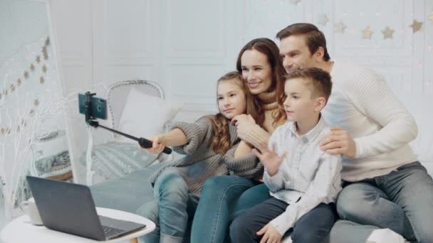 Χαμογελαστή οικογένεια κάνοντας χειρονομία νίκης μπροστά από το κινητό στο πολυτελές σπίτι — Αρχείο Βίντεο