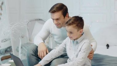 Mutlu adam özel evde defter yanında çocuk ile konuşurken.