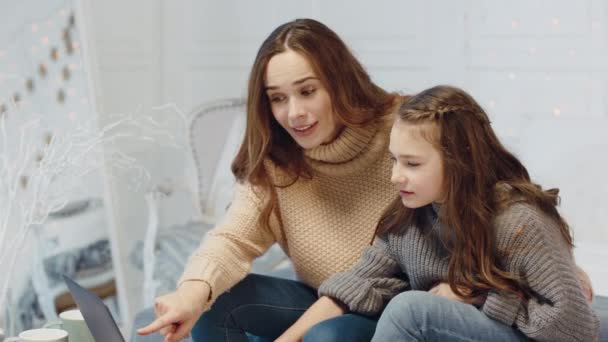 Leende mor och dotter sitter framför bärbar dator i lyxhus. — Stockvideo