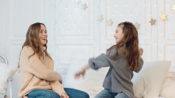 Chica feliz y mamá bailando en la cama en vacaciones de año nuevo . — Vídeos de Stock