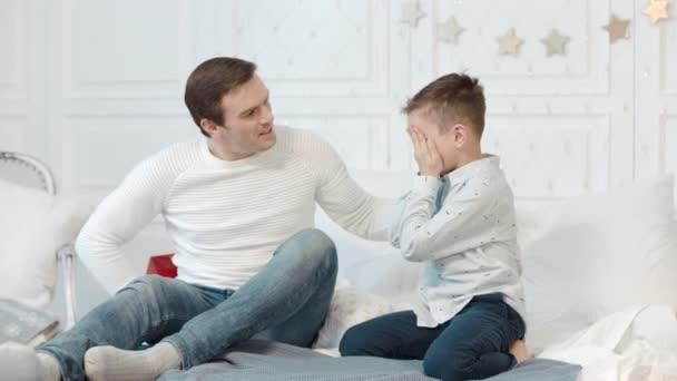 Neşeli baba oturma odasında oğluna hediye sunuyor. Mutluluğu ifade eden çocuk — Stok video
