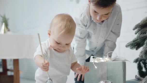 Lindo niño jugando al oropel en la sala de estar. Primer plano niño pequeño serio . — Vídeos de Stock